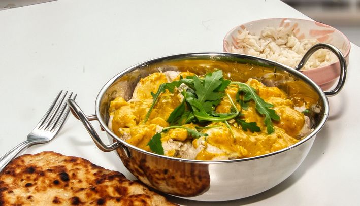 Indian curry with naan bread and rice served in a bowl