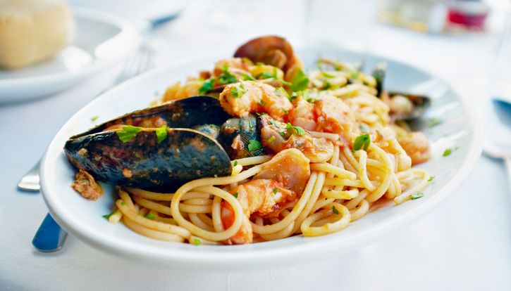 Seafood pasta dish with mussels and shrimp on a white plate