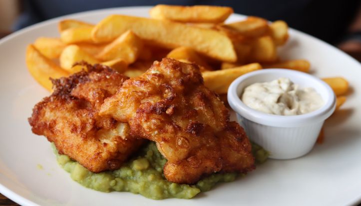 Plate of fish and chips with mushy peas and tartar sauce