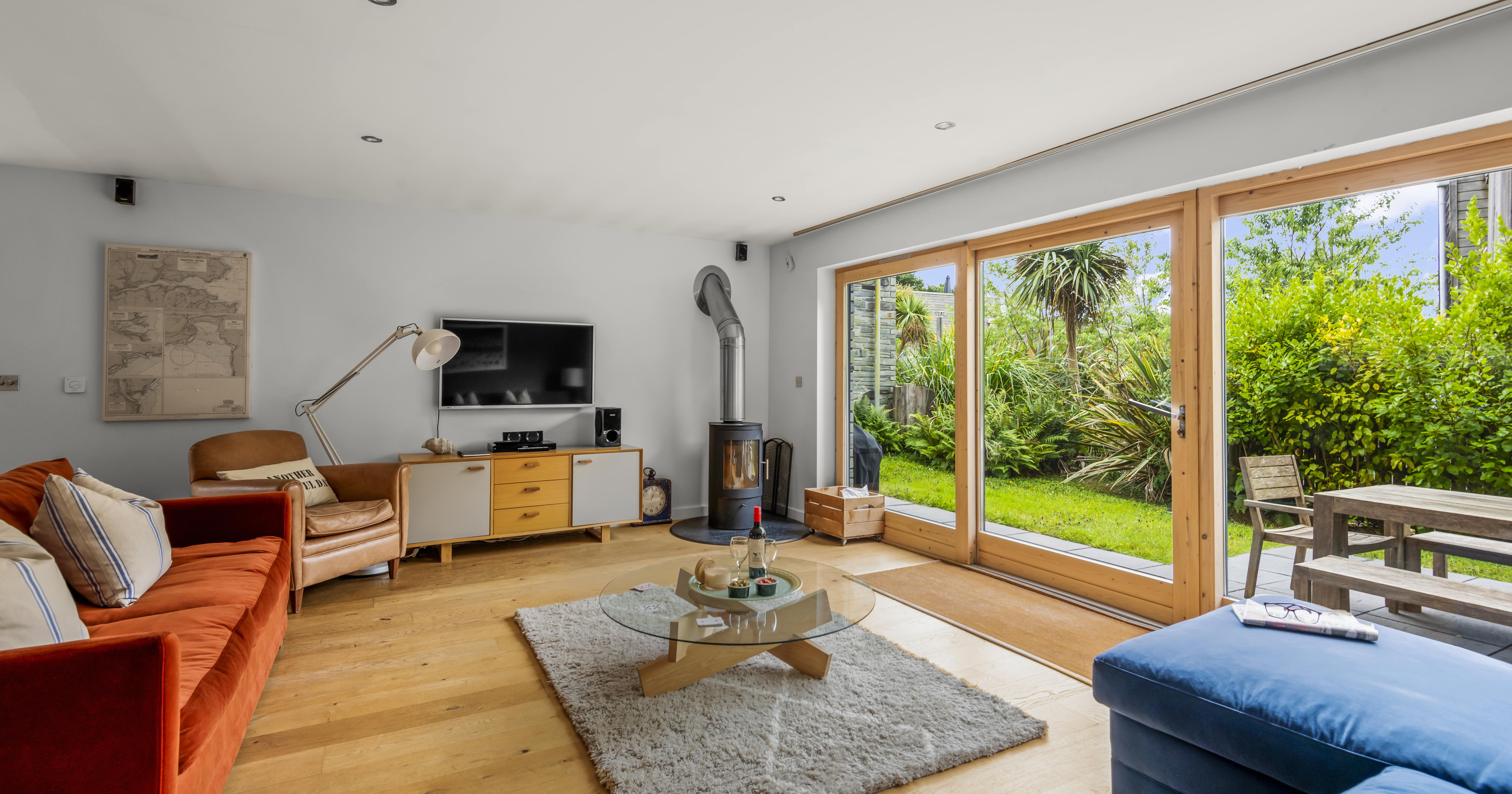 Modern living room with large glass doors opening to a lush garden