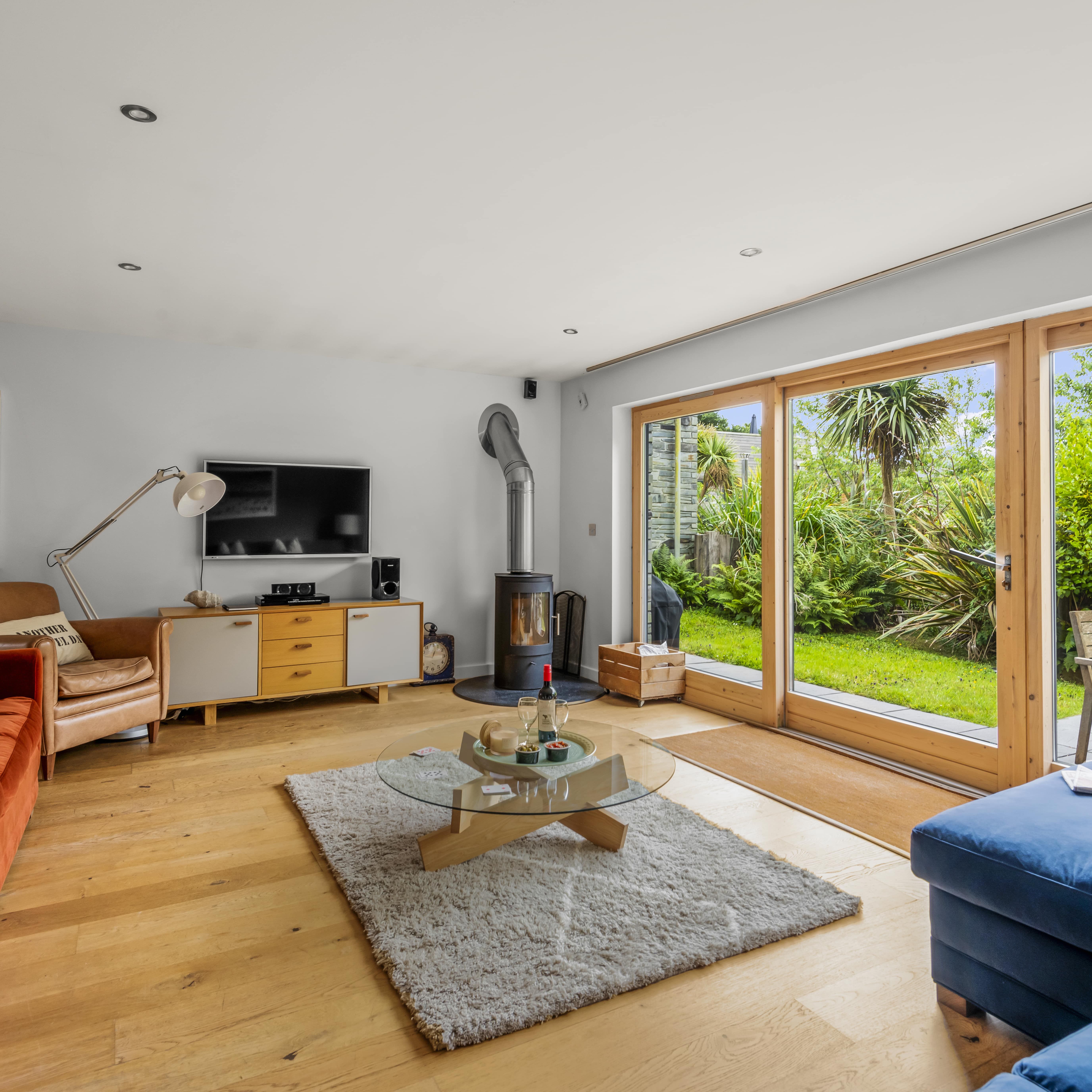 Modern living room with large glass doors opening to a lush garden