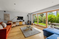 Modern living room with large glass doors opening to a lush garden