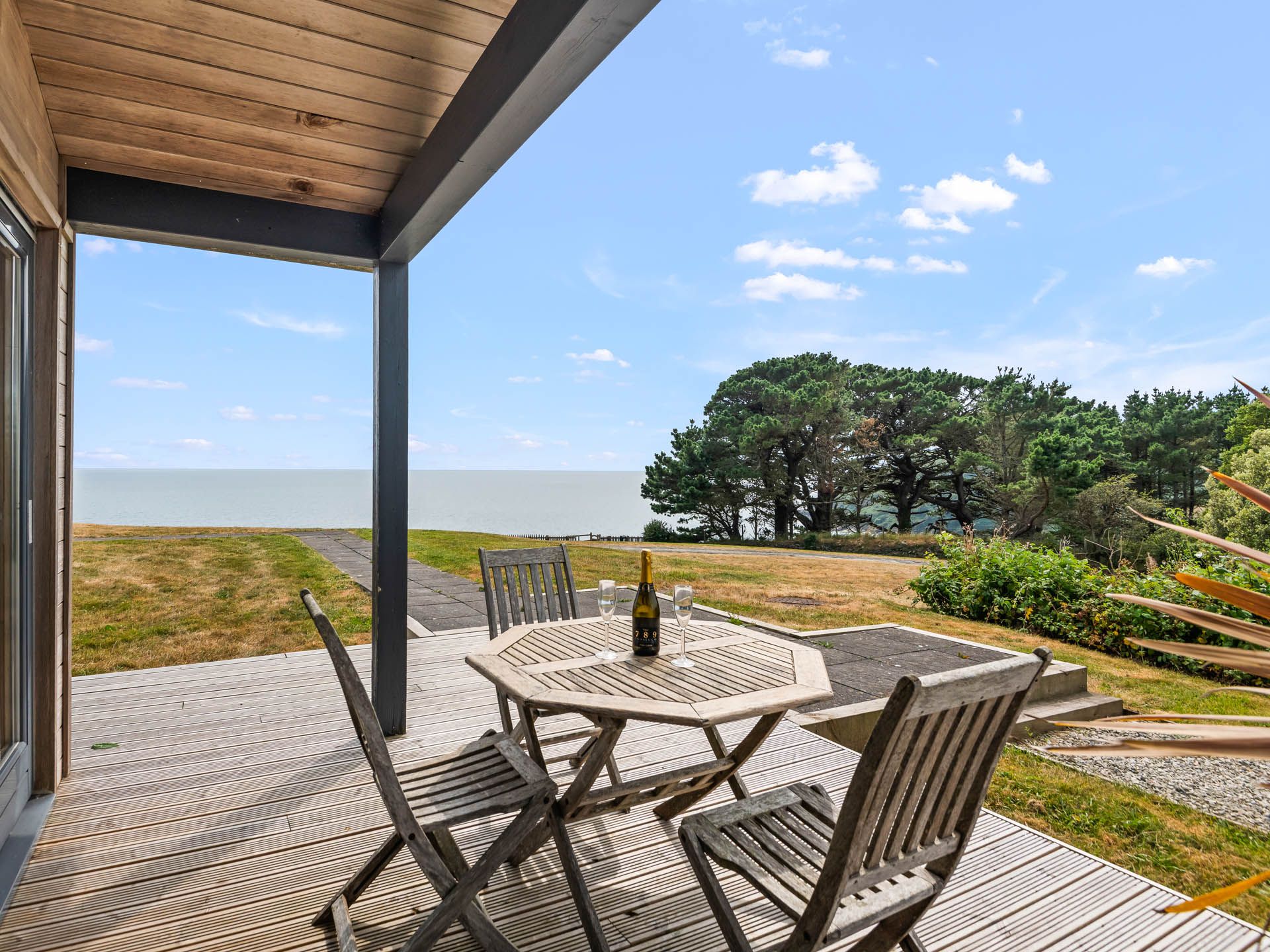 Wooden terrace with outdoor table and chairs overlooking the sea