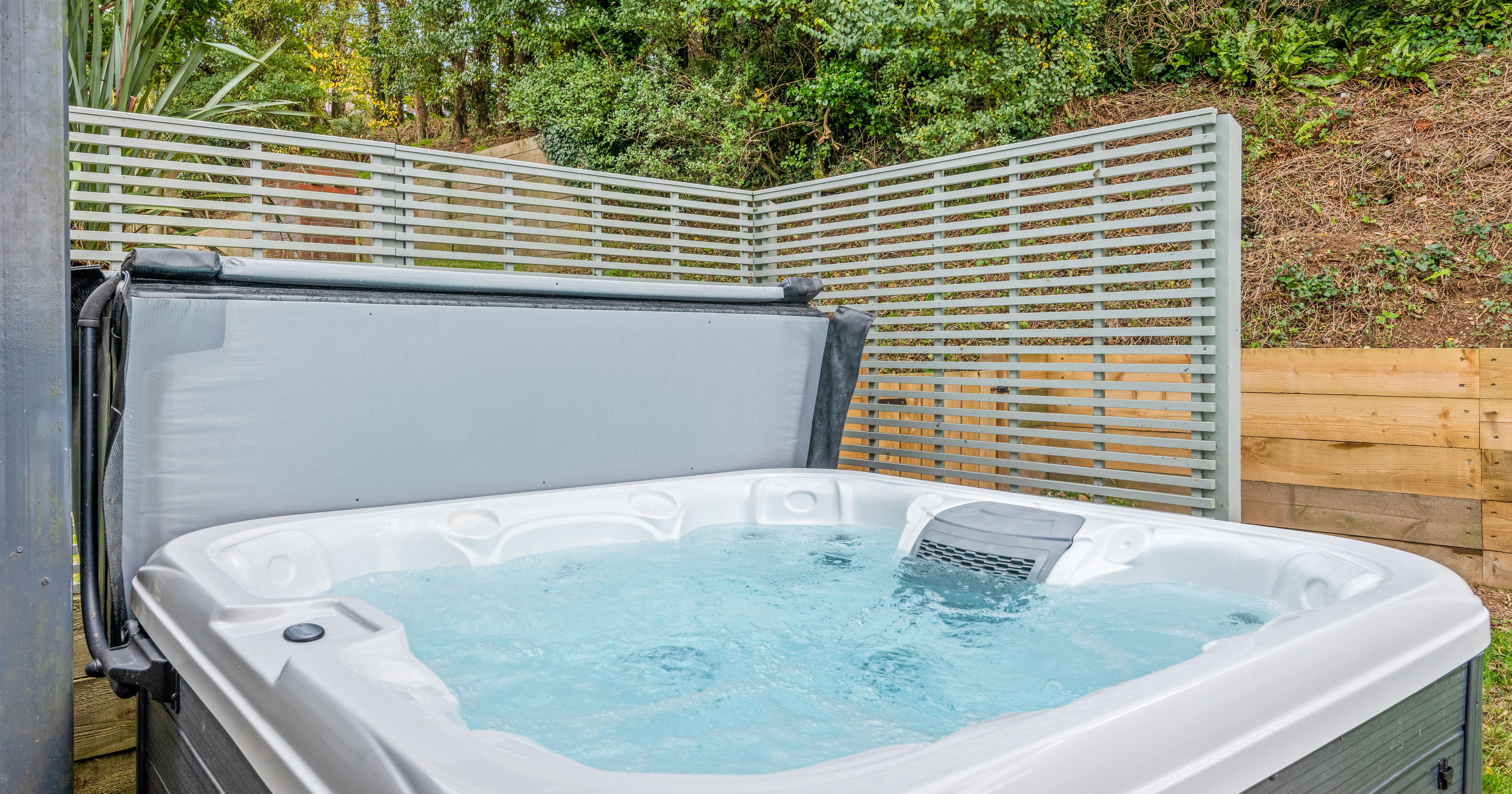 Outdoor hot tub with bubbling water and privacy screens