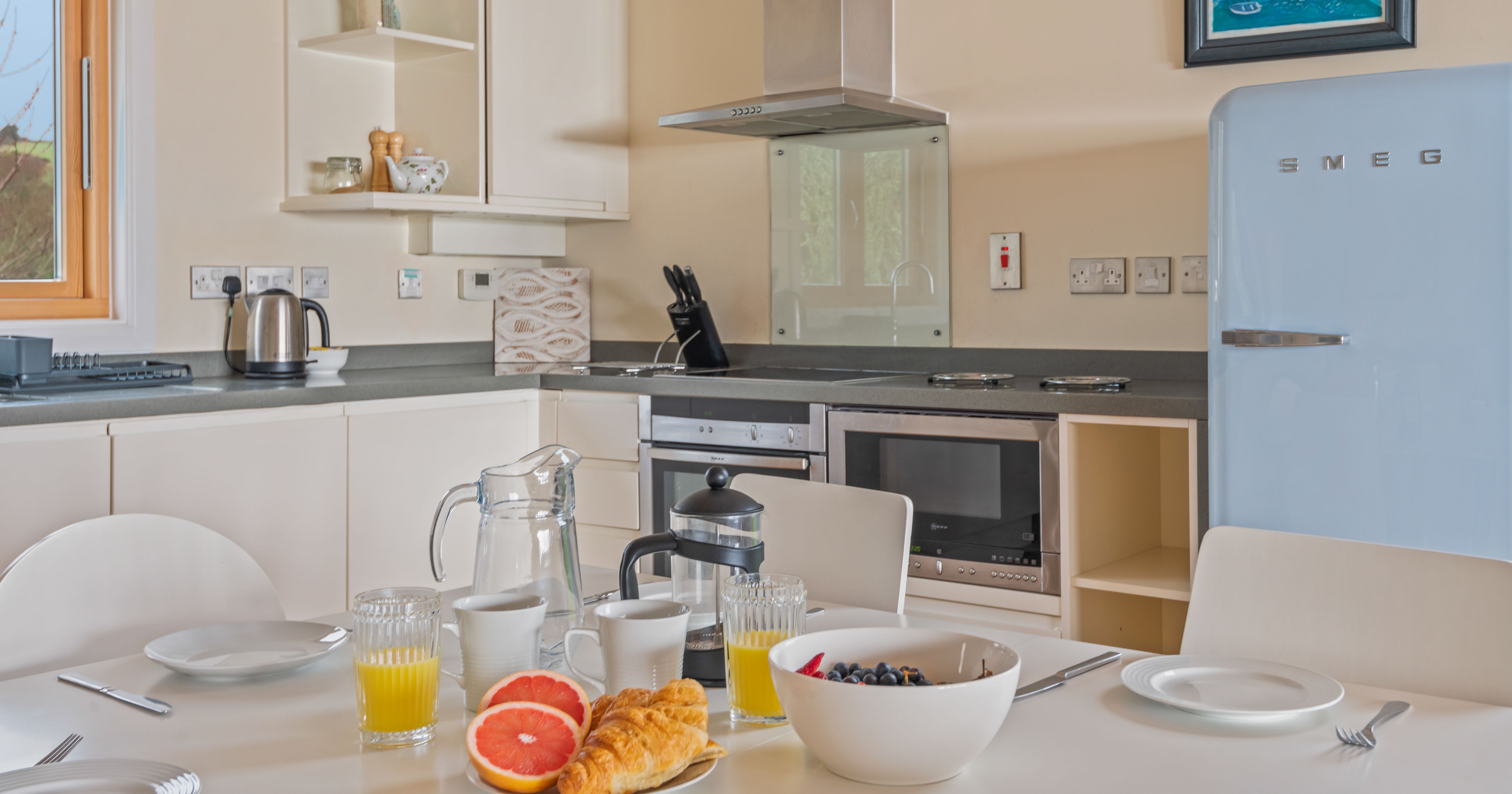 Modern kitchen and dining area with breakfast set on the table