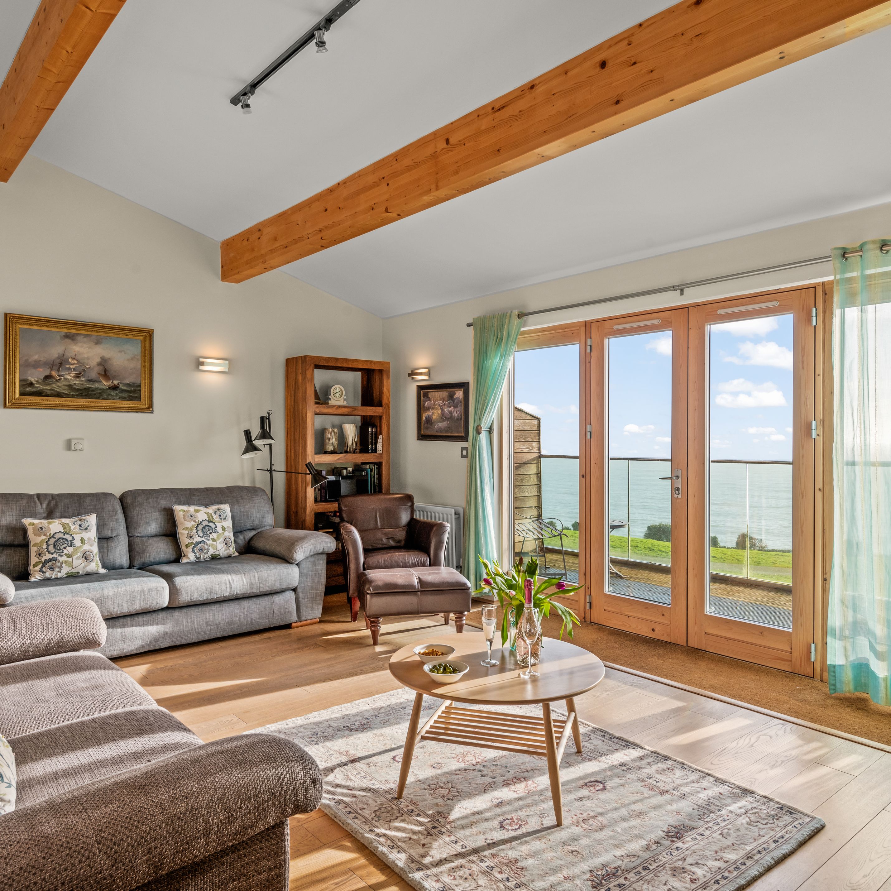 Bright and cozy living room with large windows and ocean view