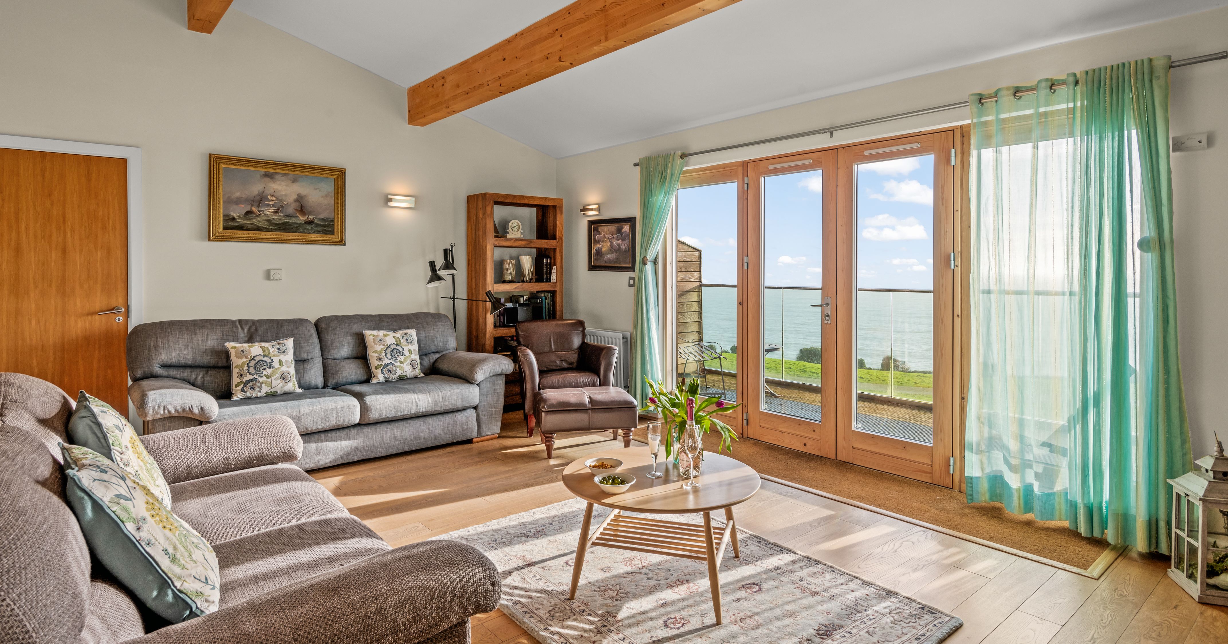 Bright and cozy living room with large windows and ocean view