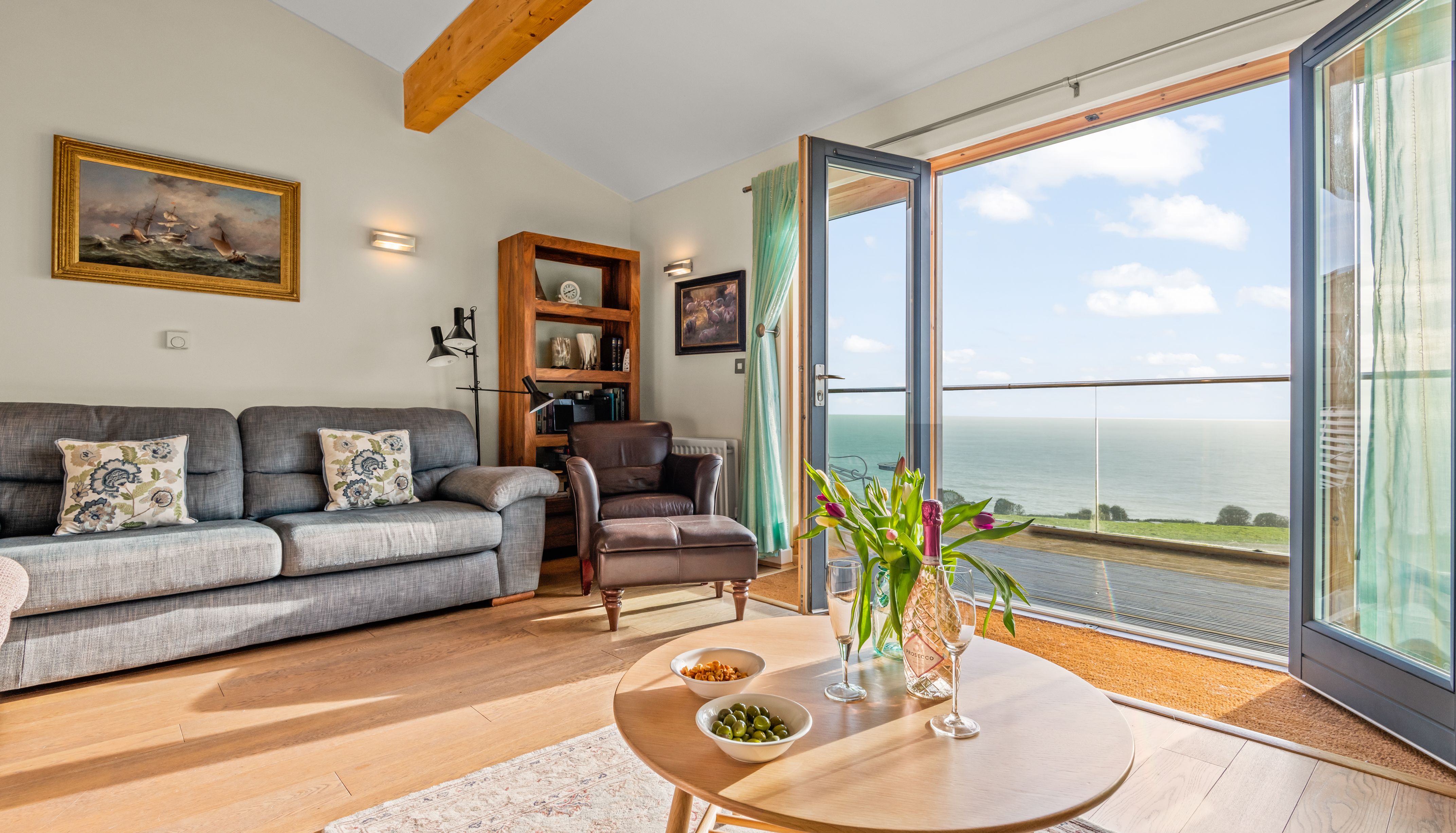 Cozy living room with sea view through open glass doors