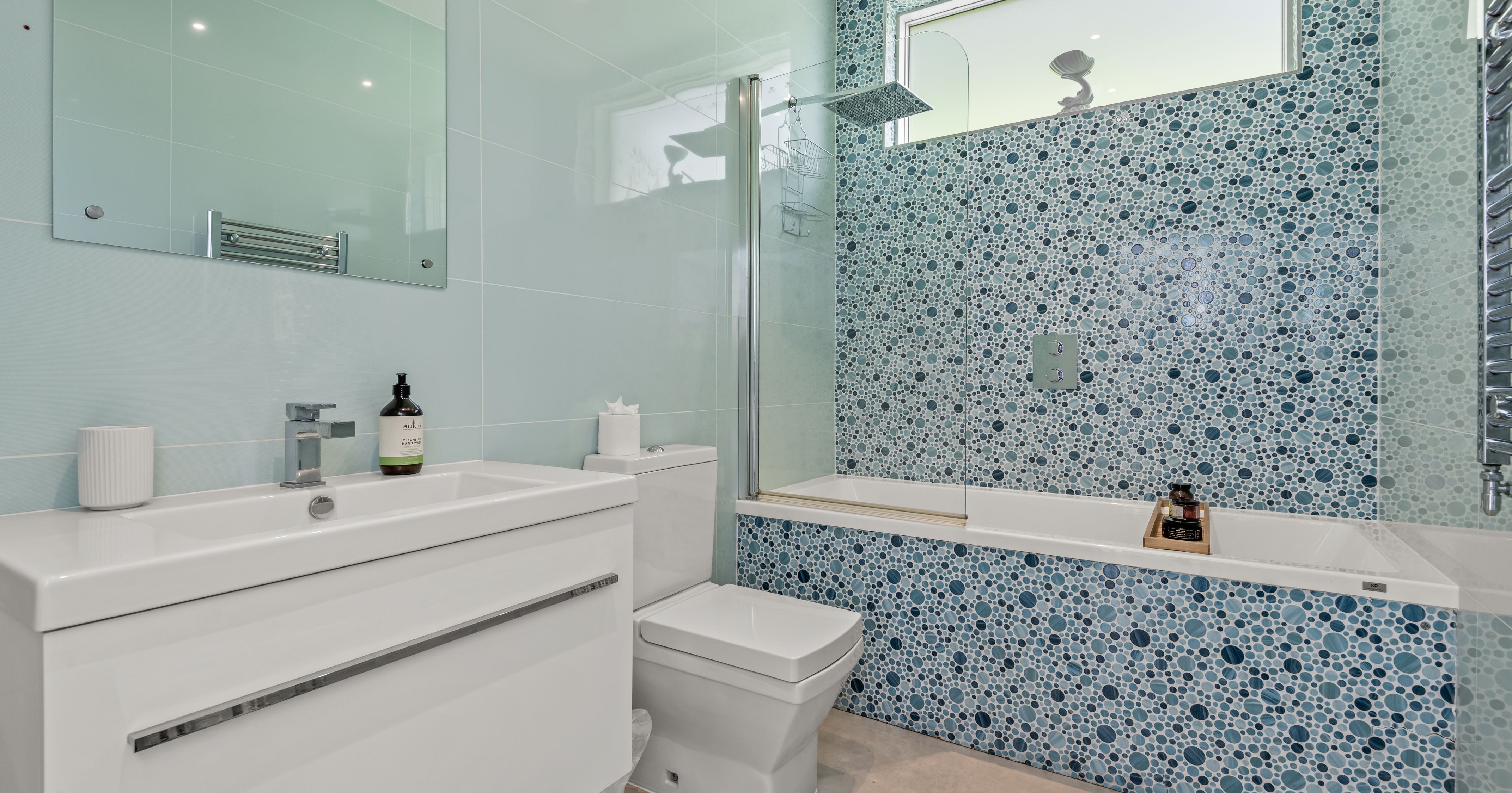 Modern bathroom with blue mosaic tiles and white fixtures