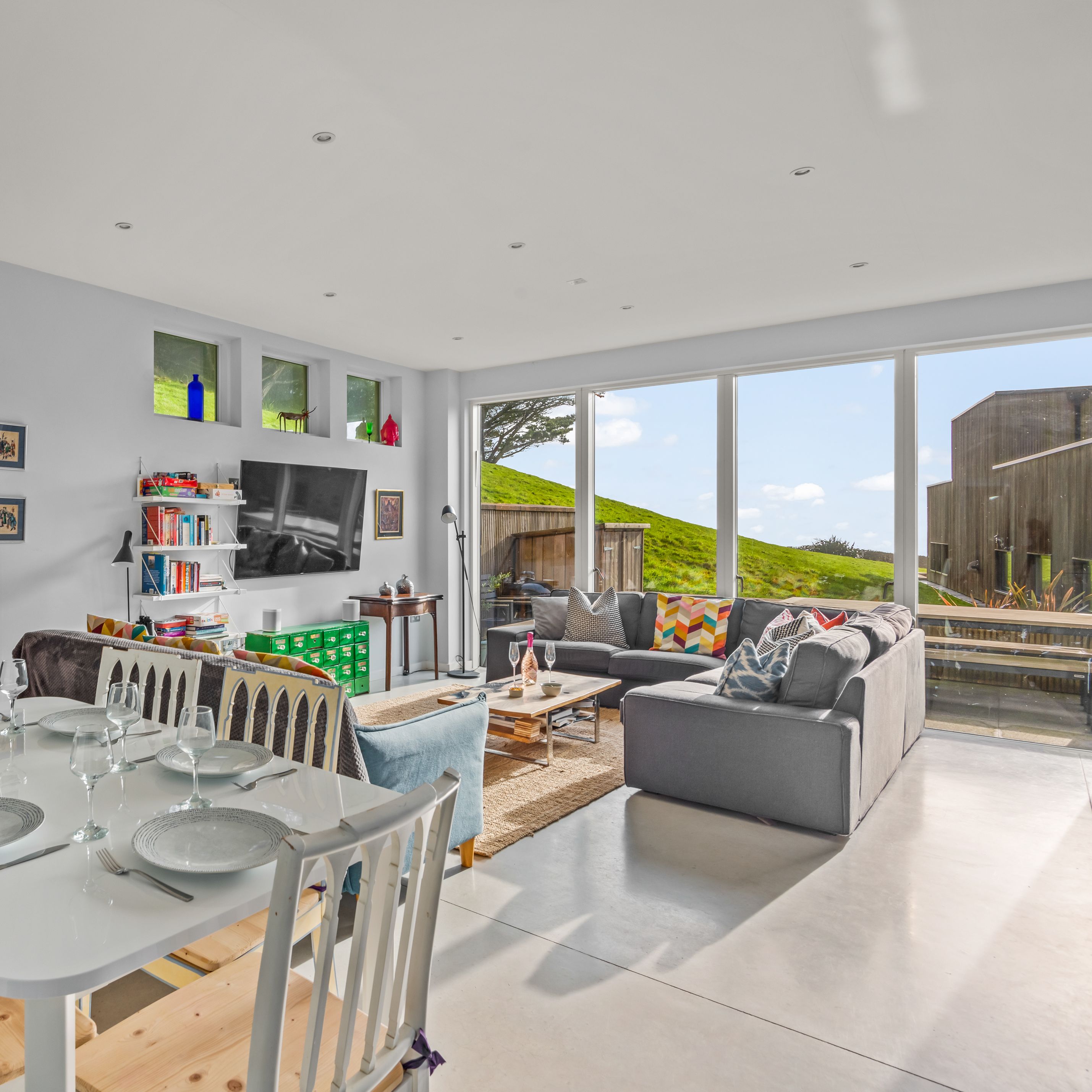 Modern open-plan living and dining room with large windows and contemporary decor