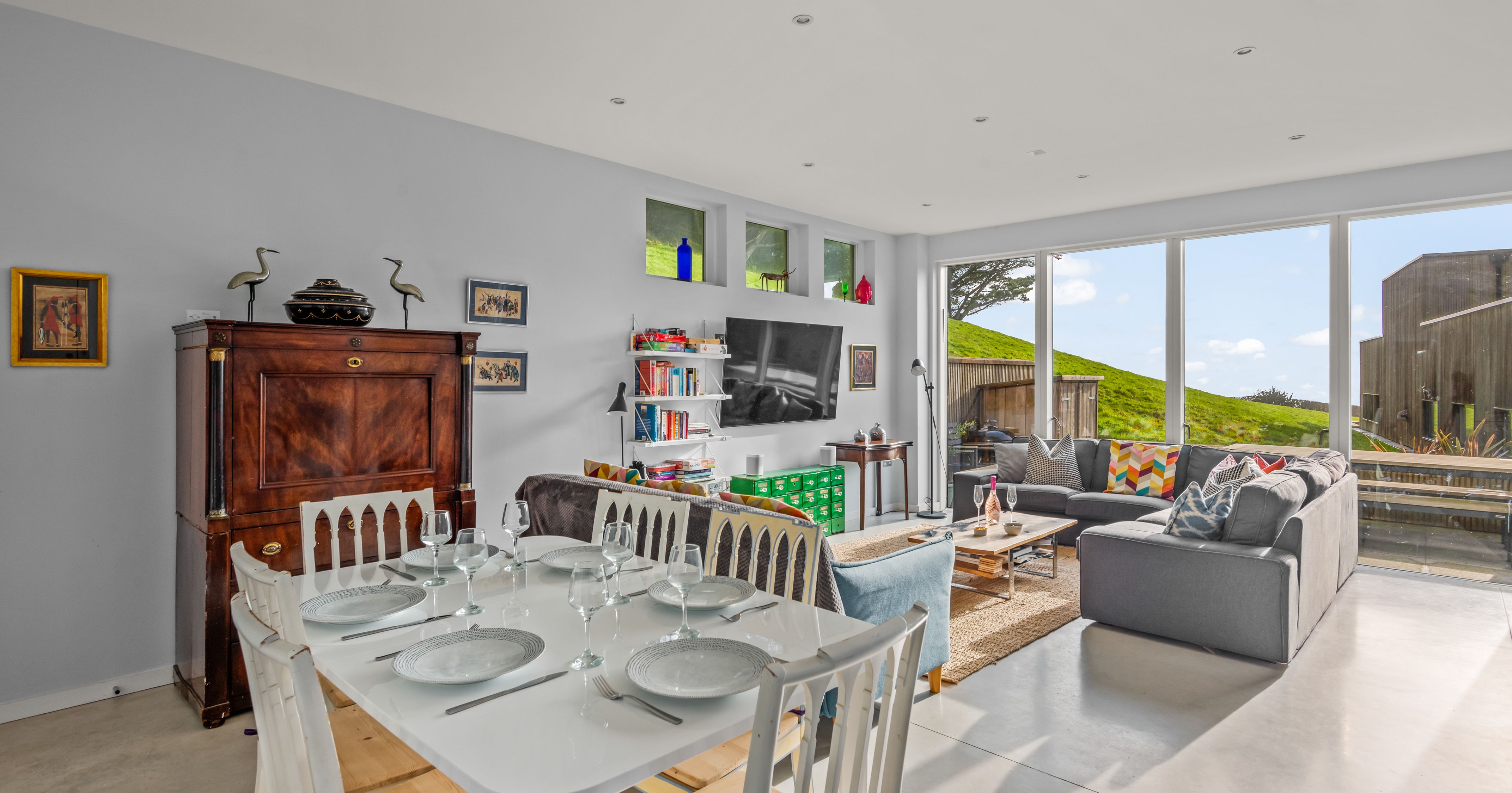 Modern open-plan living and dining room with large windows and contemporary decor