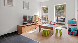 Bright playroom with wooden furniture, children's toys, and a TV.