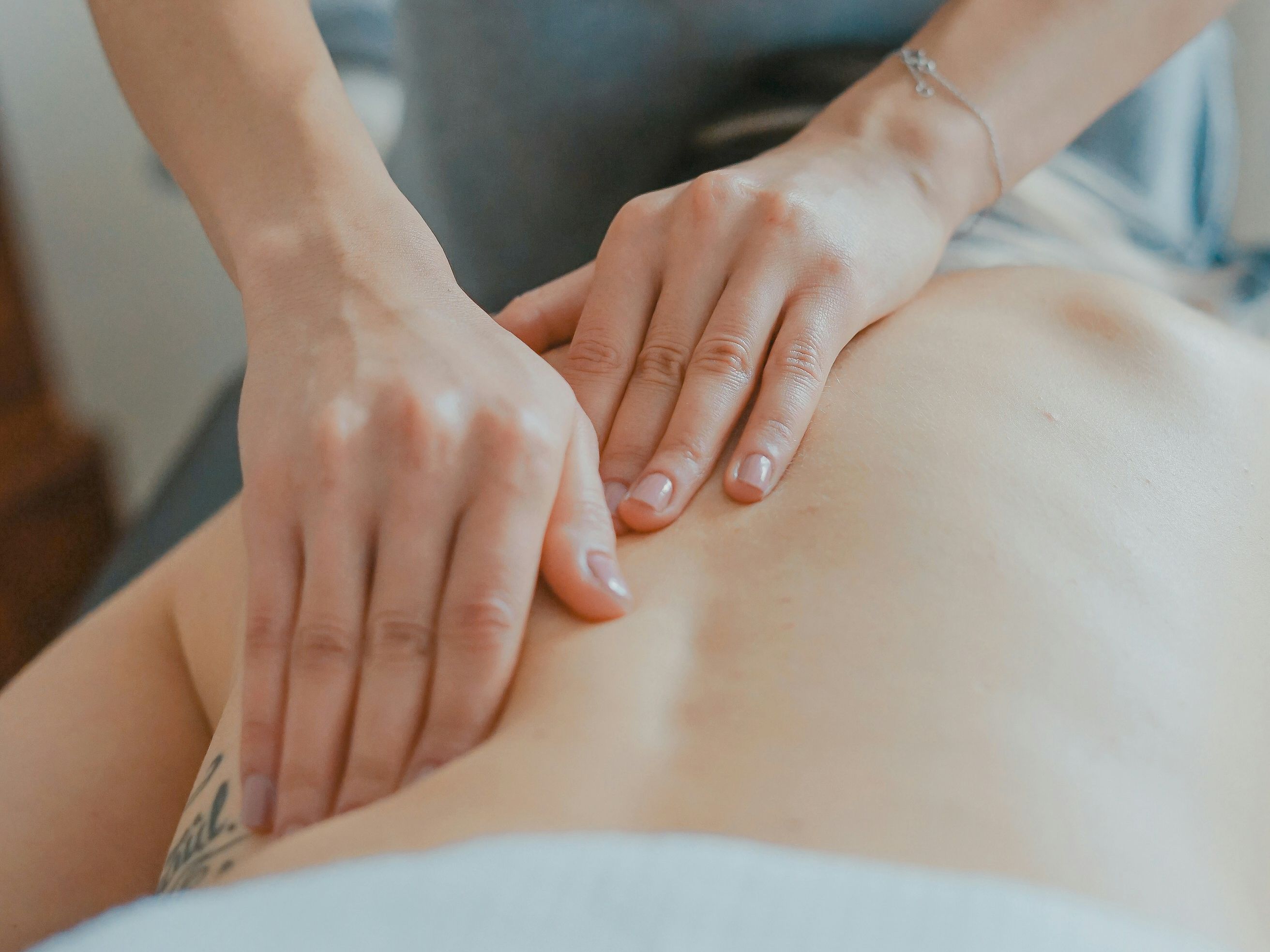 Person receiving a back massage by a massage therapist