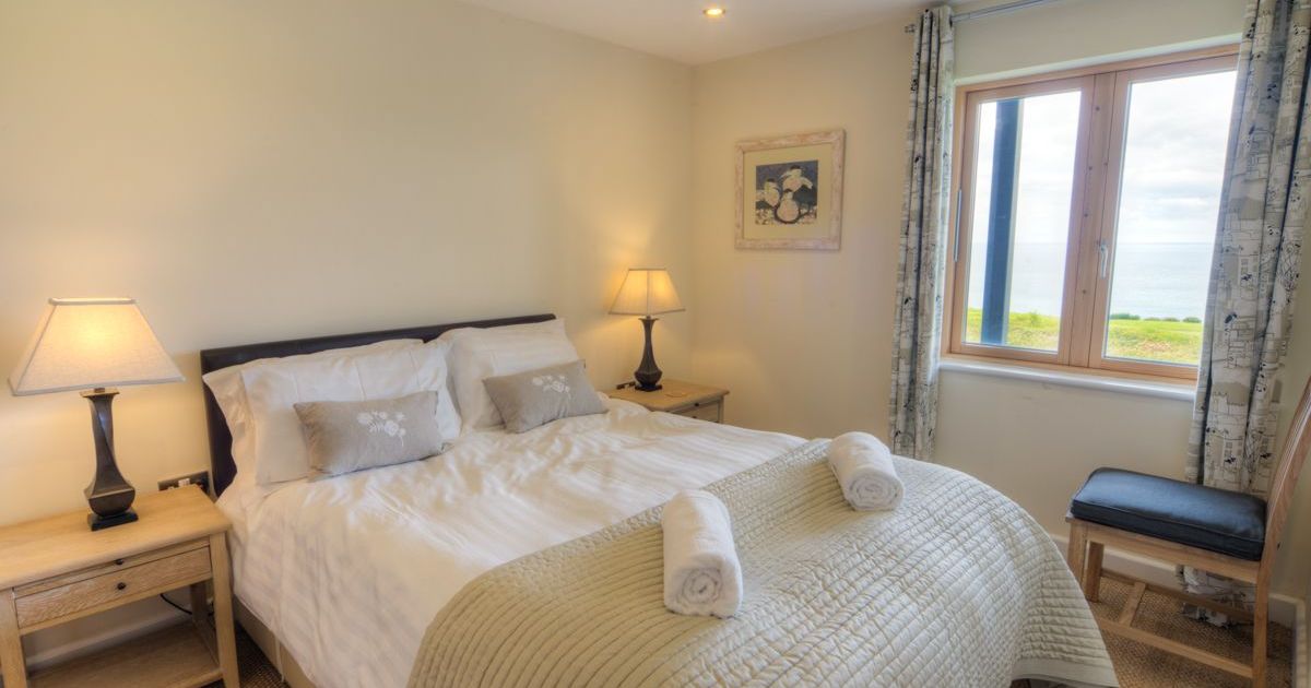 Cozy bedroom with double bed, two lamps, window with sea view