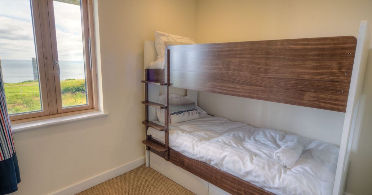 Small bedroom with bunk beds and a window overlooking the sea