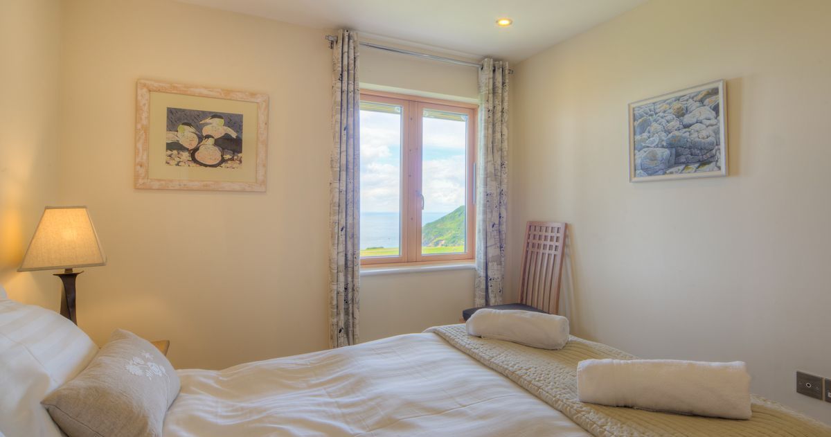 Cozy bedroom with a double bed, window view, and wall art