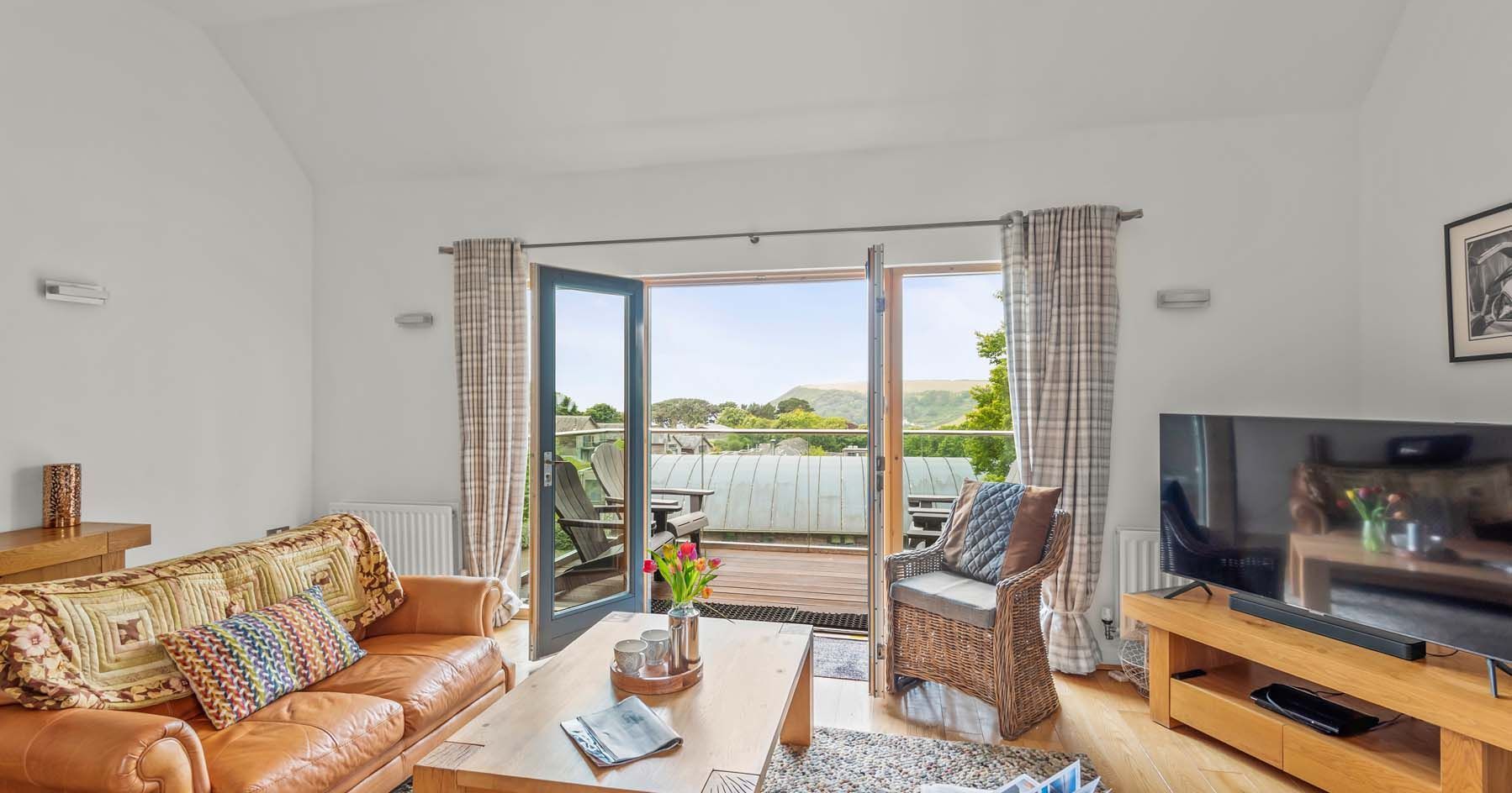 Cozy living room with open doors to a balcony and scenic view