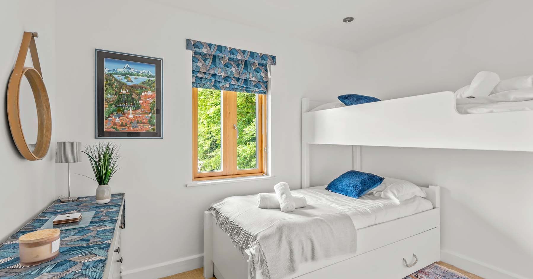 Bright and modern bedroom with bunk beds and blue accents.