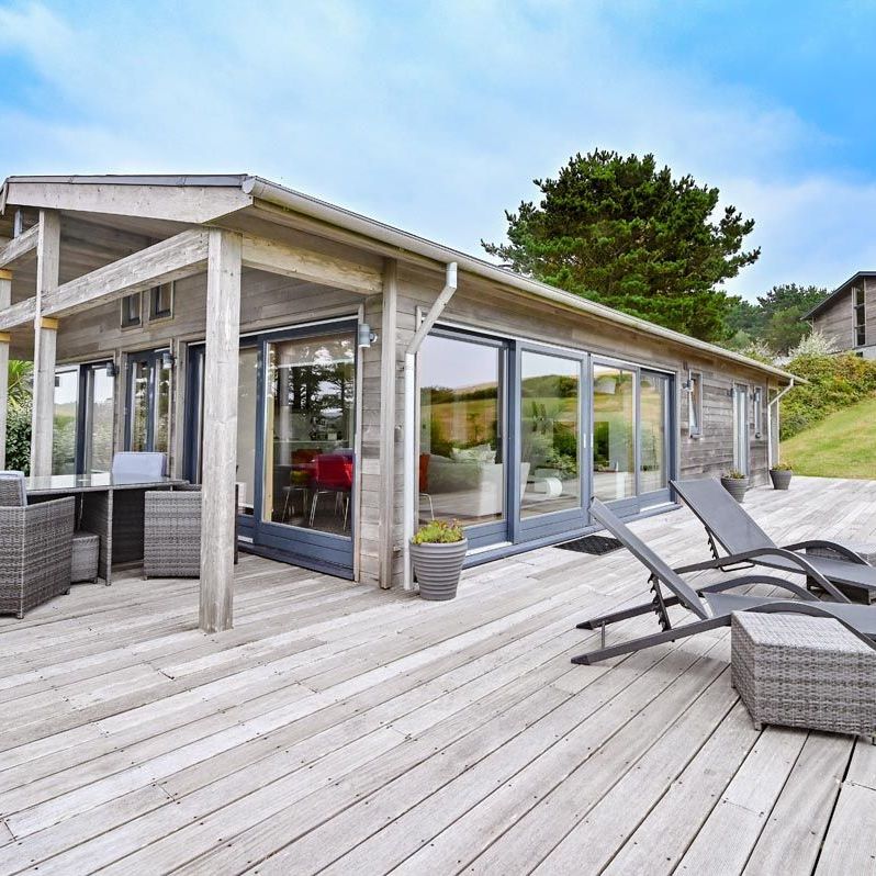 Modern wooden house with large deck and outdoor furniture