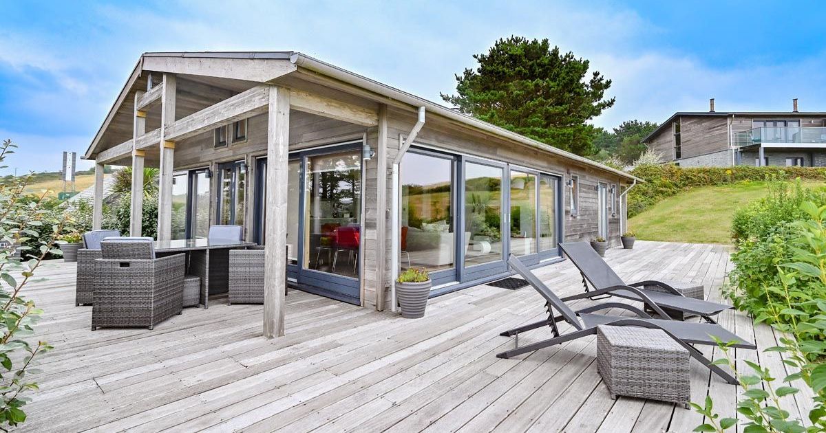 Modern wooden house with large deck and outdoor furniture