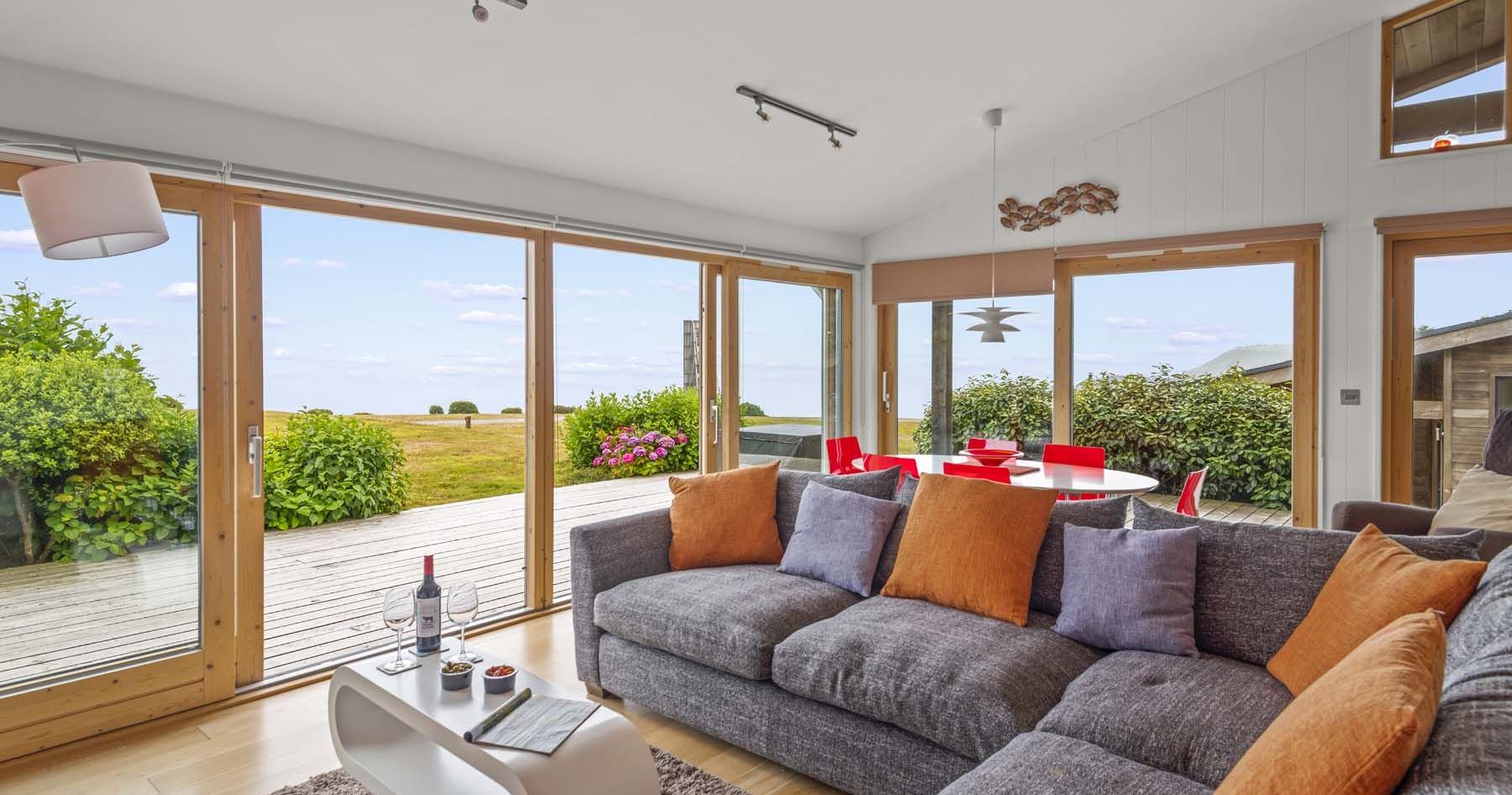 Modern living room with large windows overlooking a grassy outdoor area