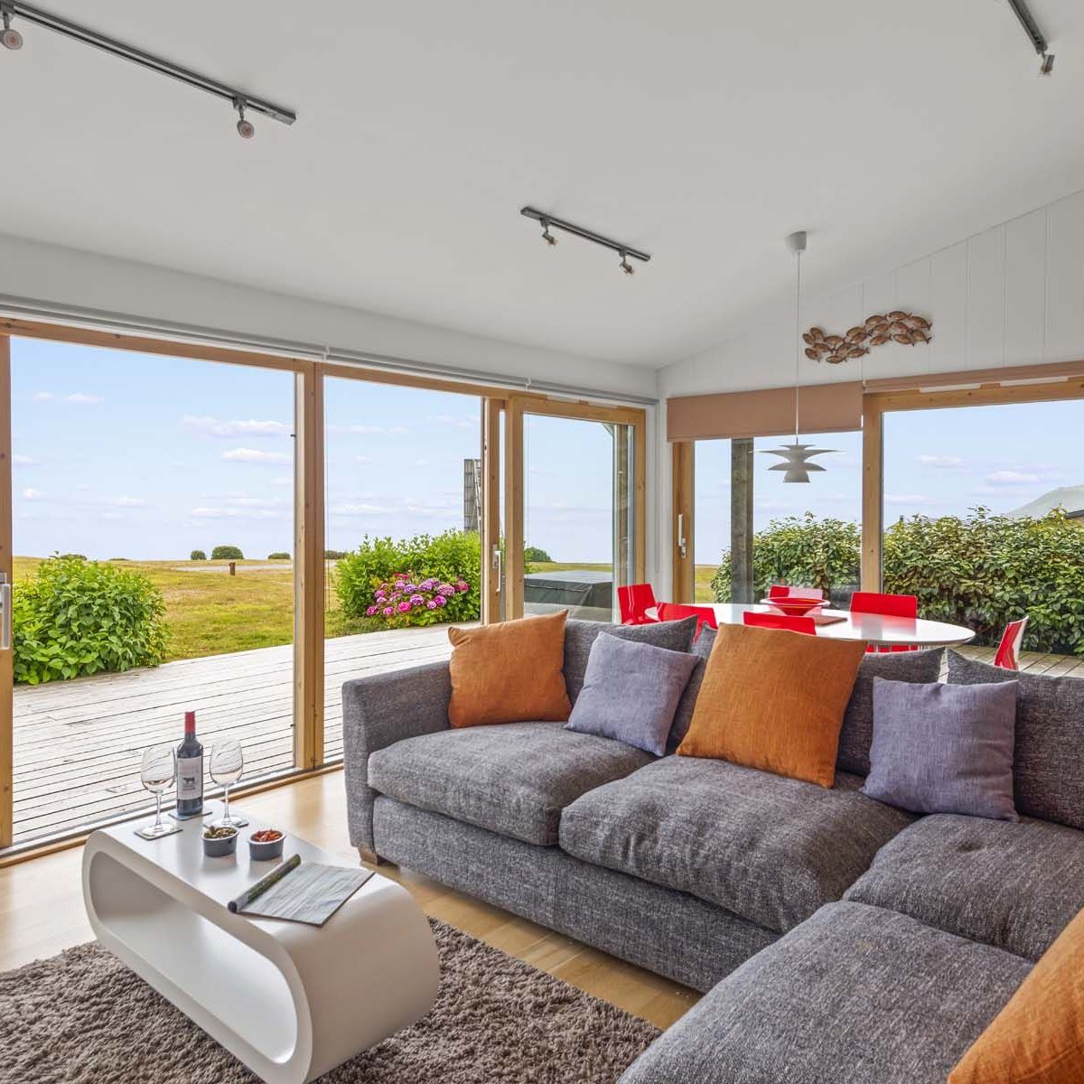 Modern living room with large windows overlooking a grassy outdoor area