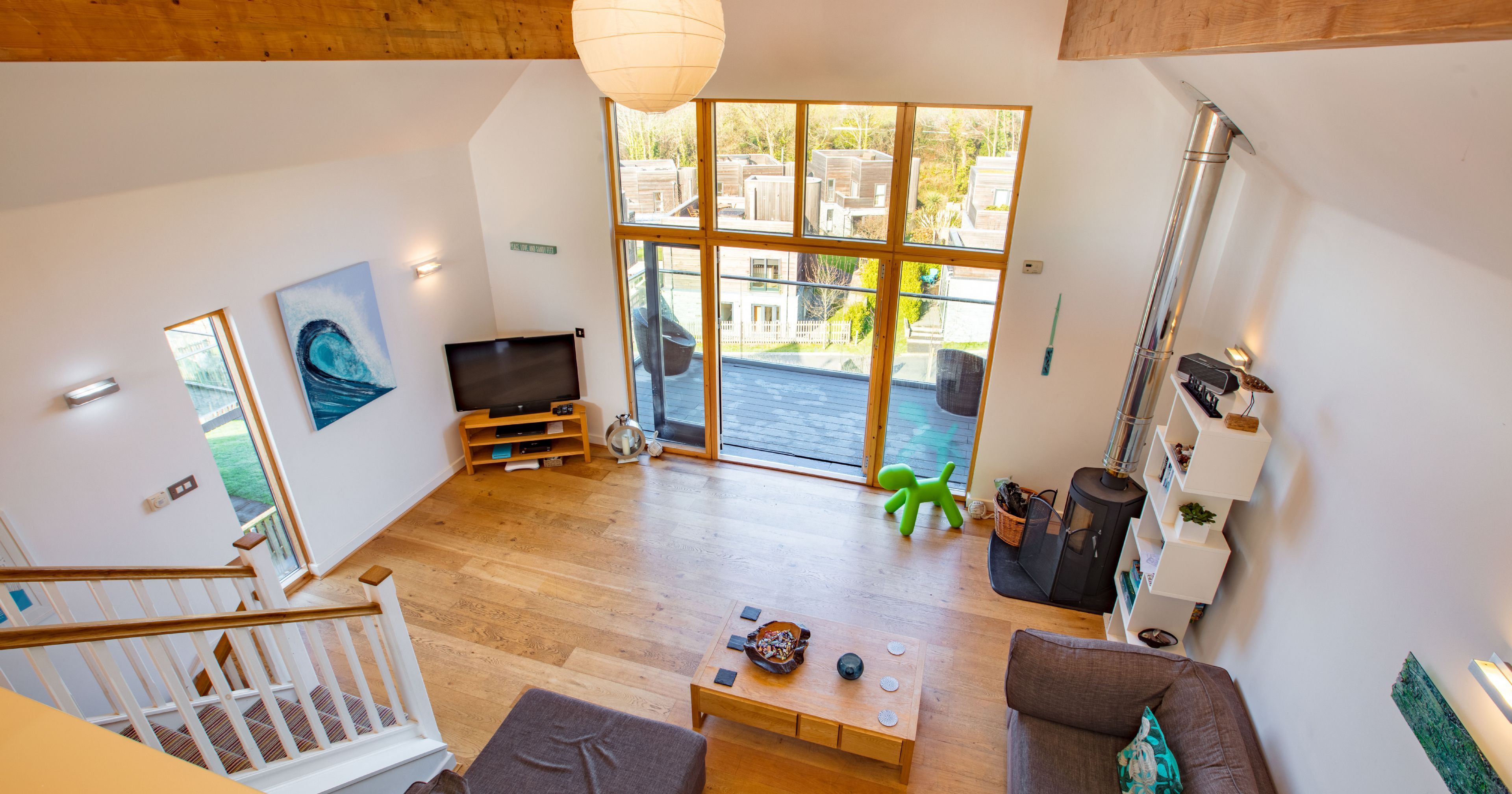 Modern living room with large windows and wooden beams viewed from above