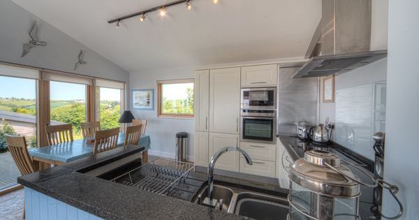 Modern kitchen and dining area with large windows and countryside view