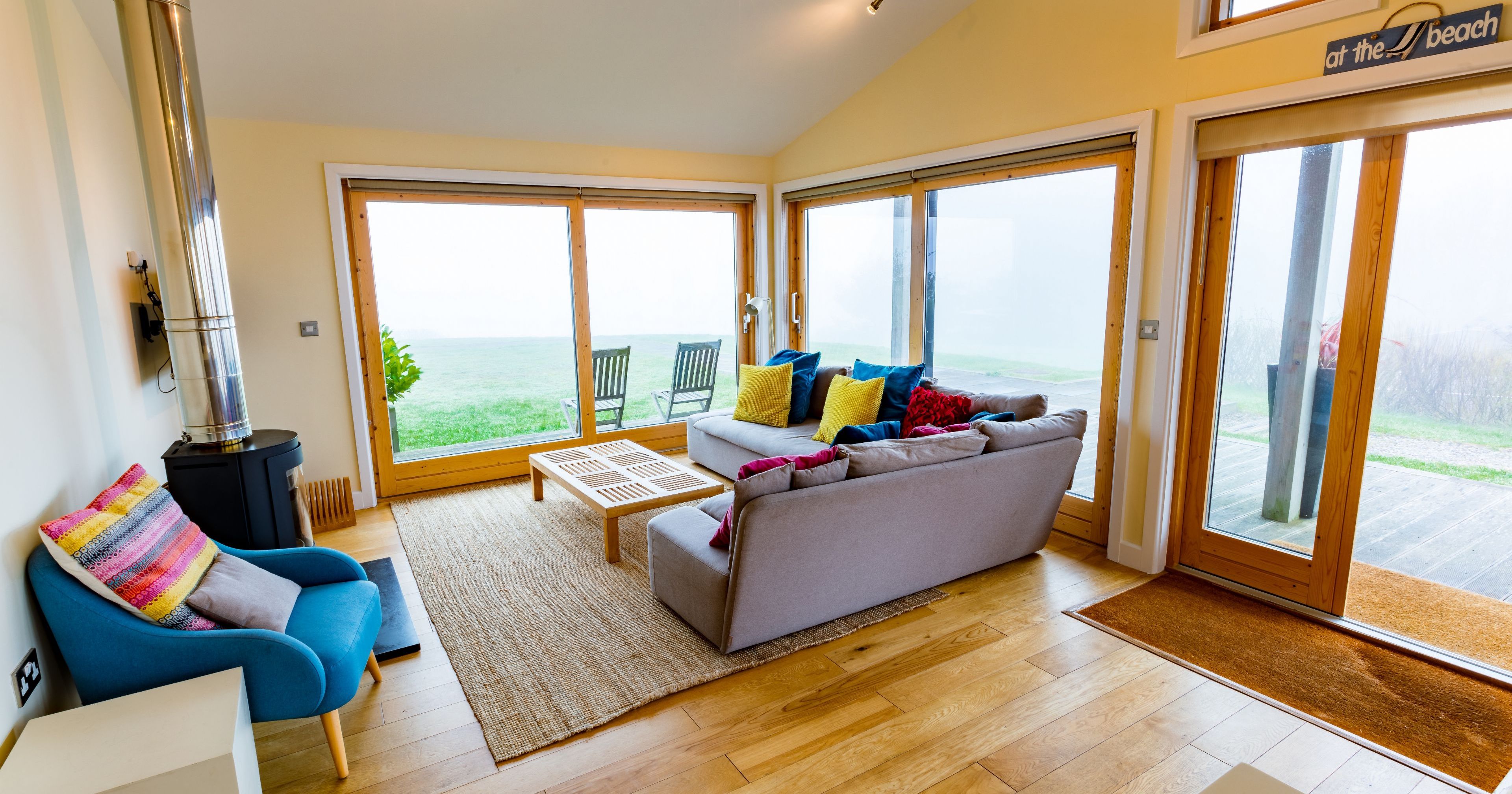 Modern beach house living room with large windows and colorful furniture