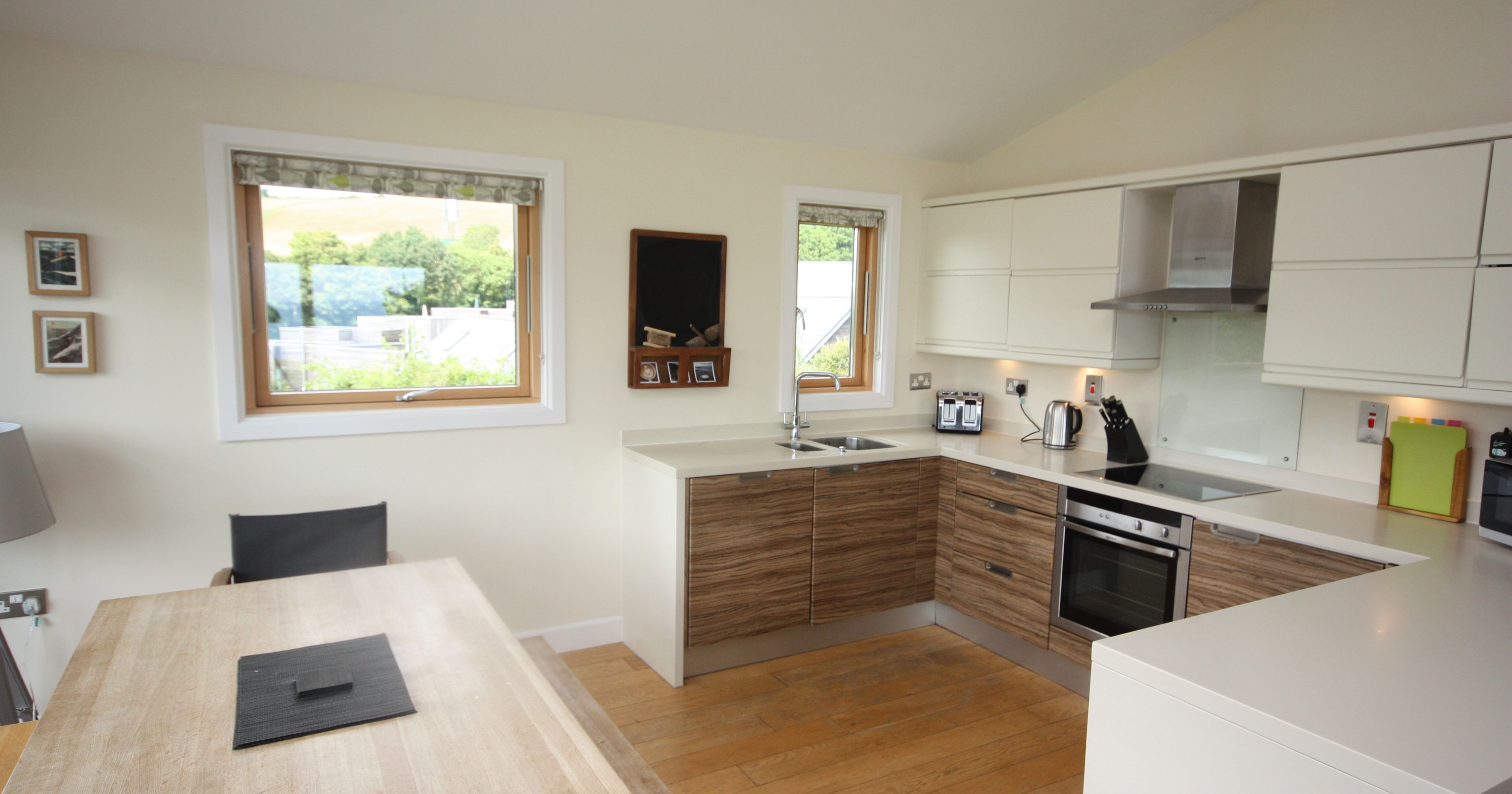 Modern kitchen with wooden cabinets, white countertops, and dining table