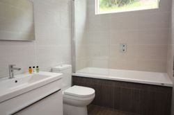 Modern bathroom with bathtub, toilet, and sink