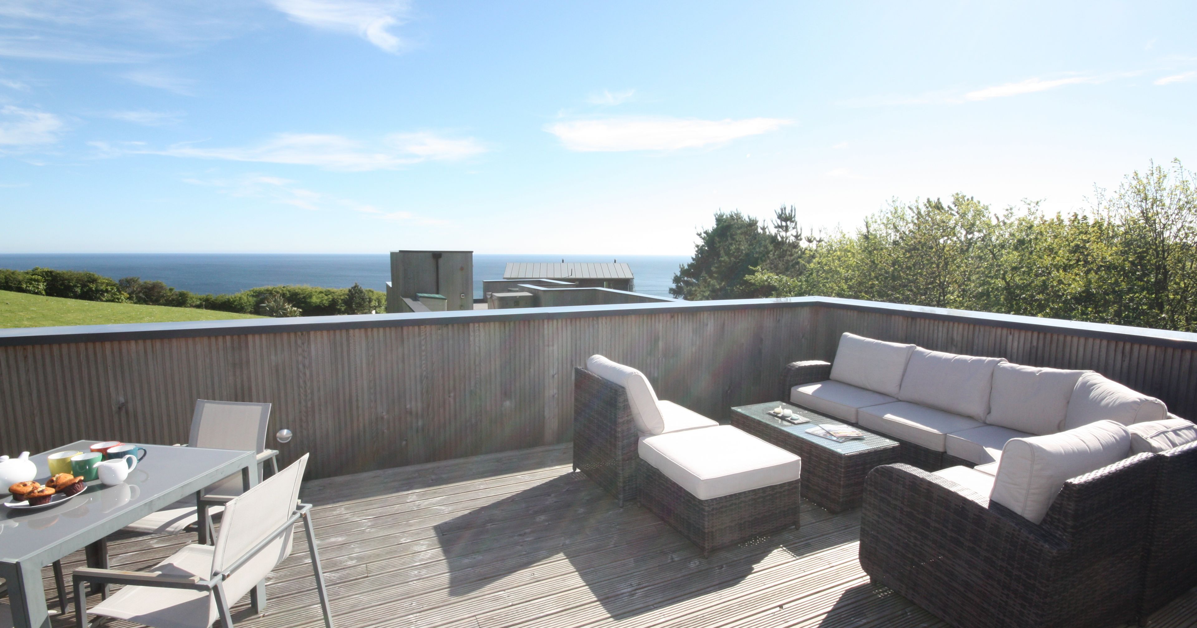 Wooden deck terrace with outdoor furniture and sea view