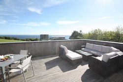 Wooden deck terrace with outdoor furniture and sea view