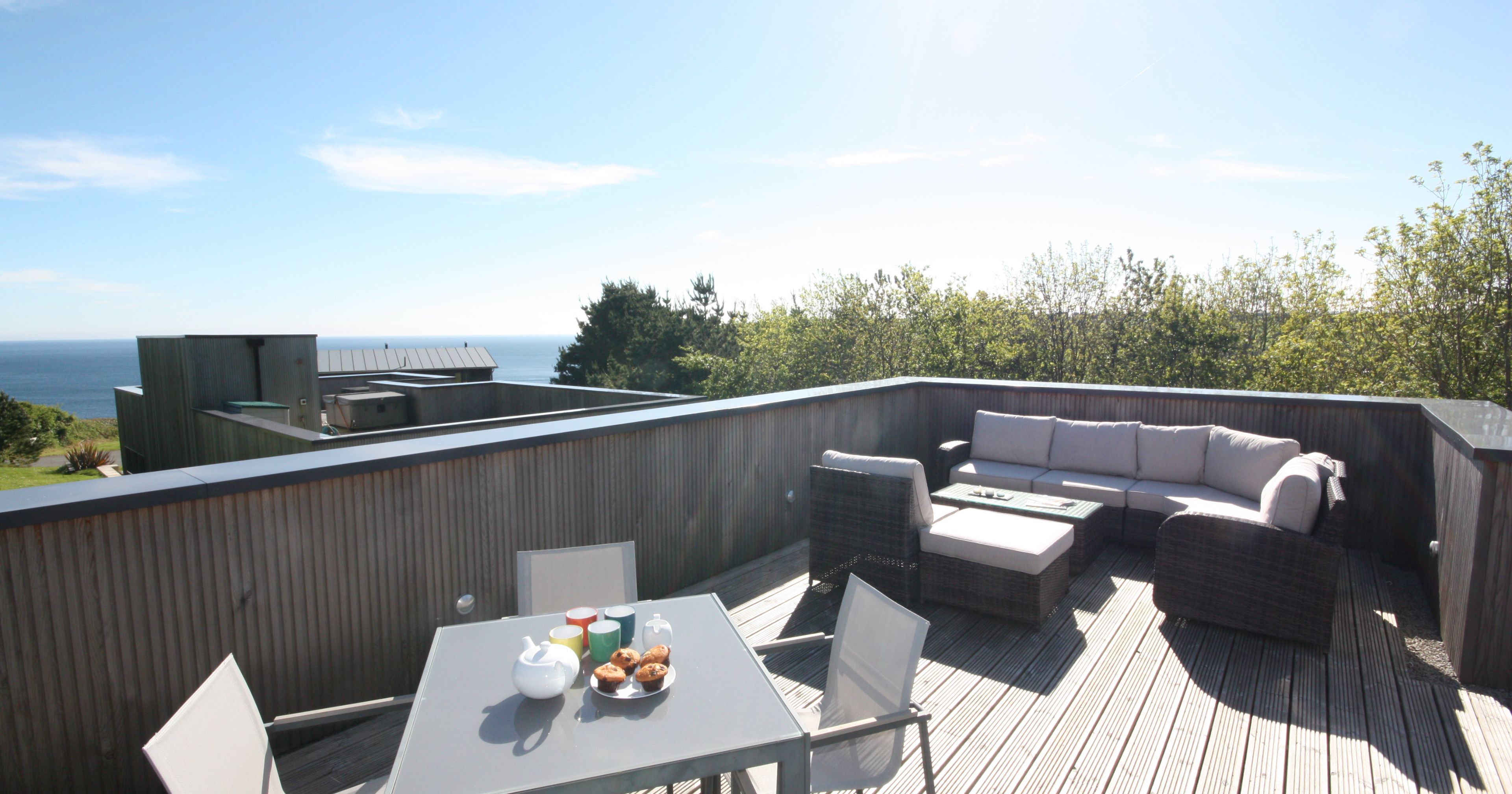 Modern rooftop terrace with outdoor furniture and ocean view