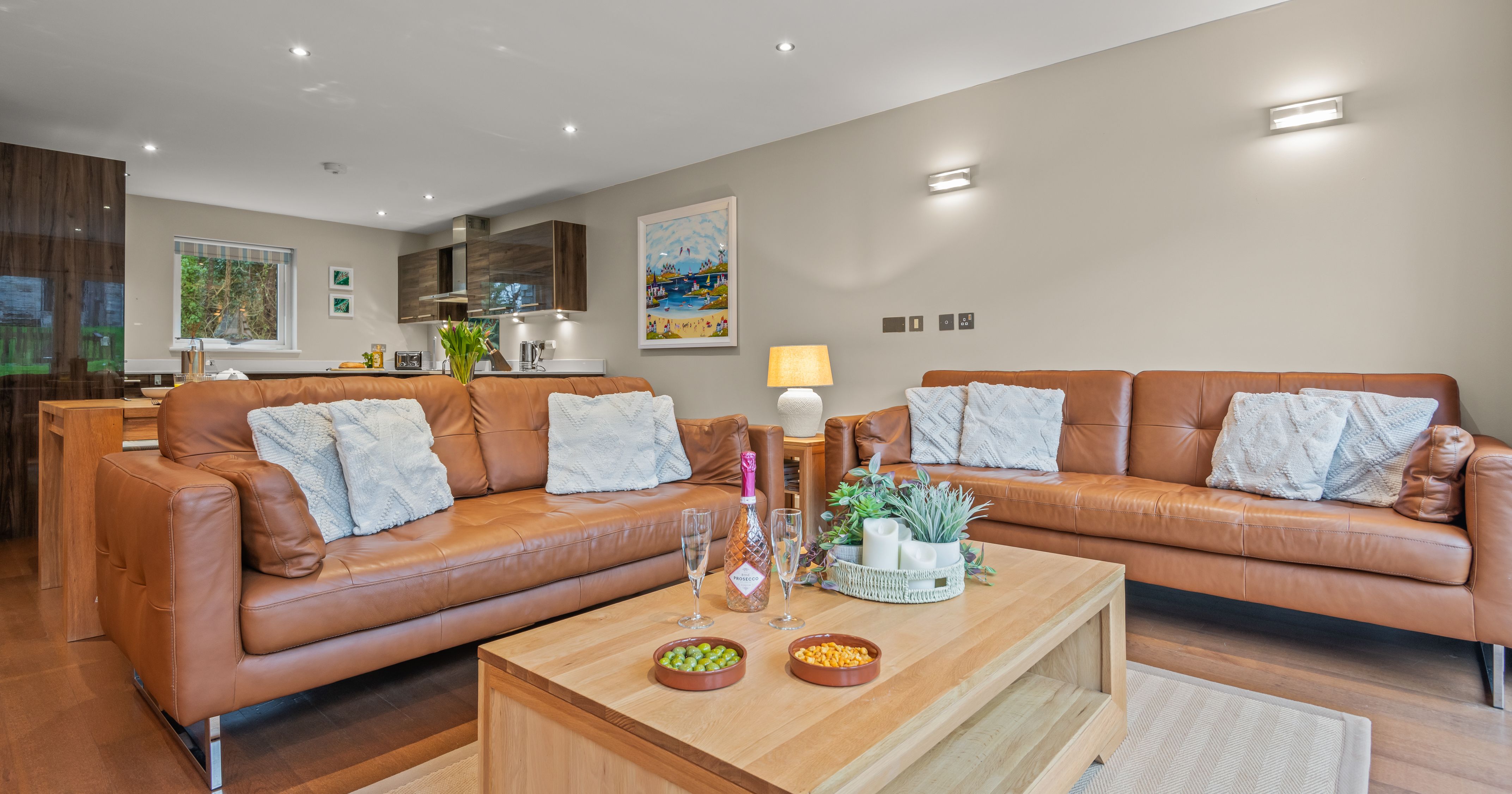 Modern living room with tan leather sofas and a wooden coffee table