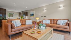 Modern living room with tan leather sofas and a wooden coffee table