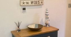 Coastal themed console table with decorative sign on the wall above.