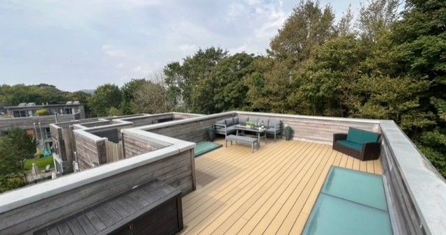Modern rooftop terrace with outdoor seating and views of trees
