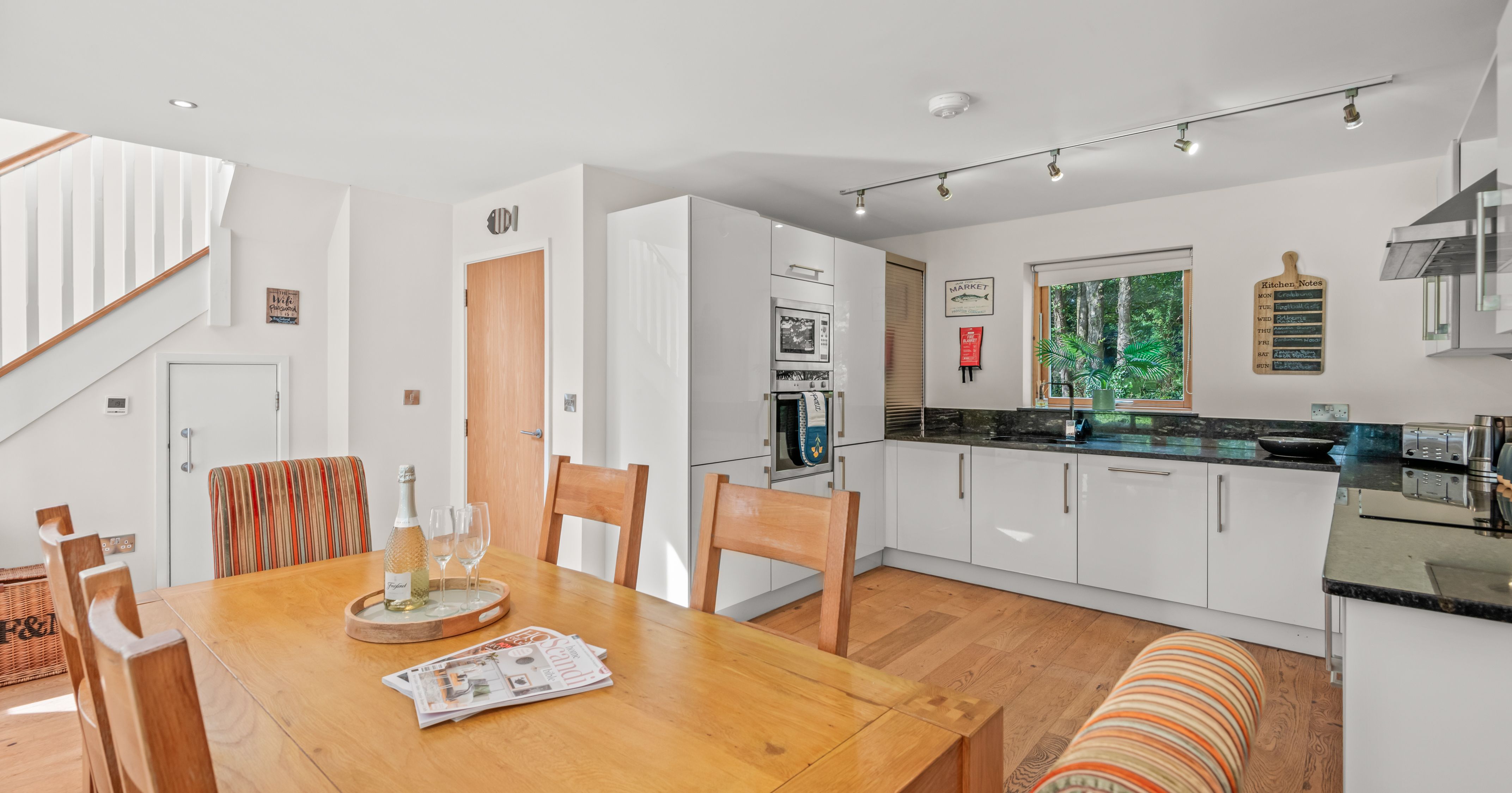 Modern kitchen and dining area with wooden table and white cabinets