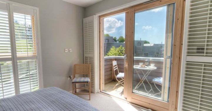 Bright bedroom with large glass doors leading to balcony