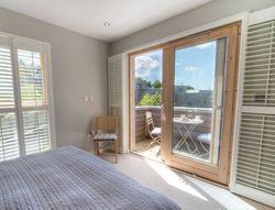Bright bedroom with large glass doors leading to balcony