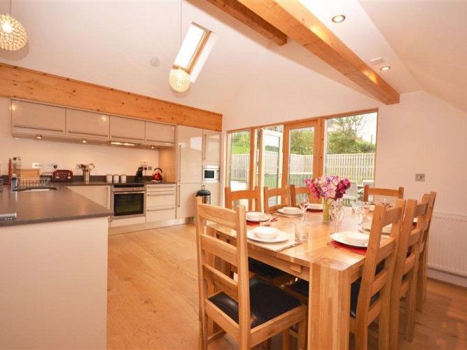 Modern kitchen and dining area with wooden beams and large windows