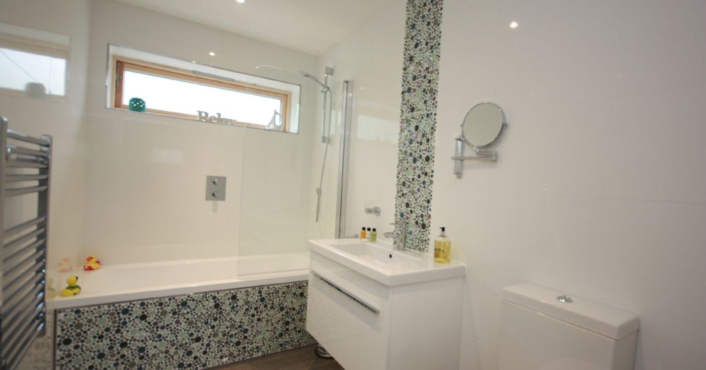 Modern bathroom with mosaic tiles and white fixtures
