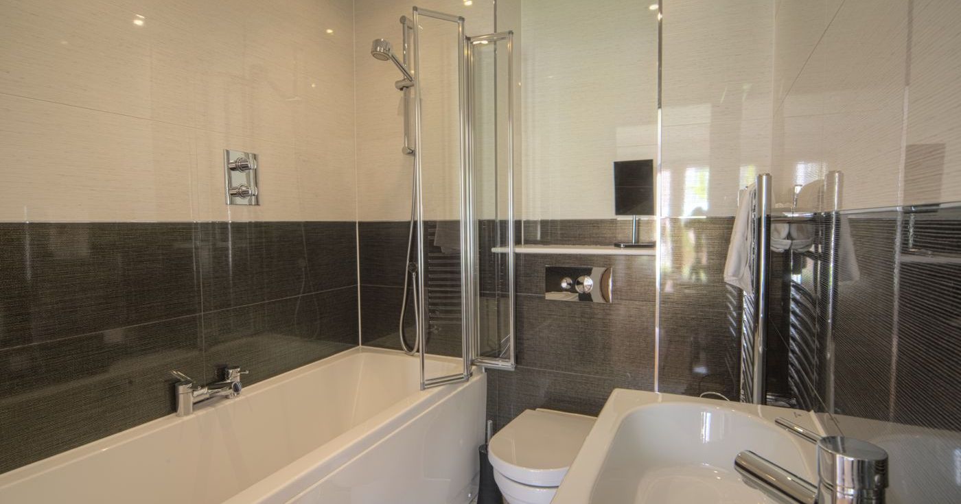 Modern bathroom with bathtub, shower, toilet, and sink