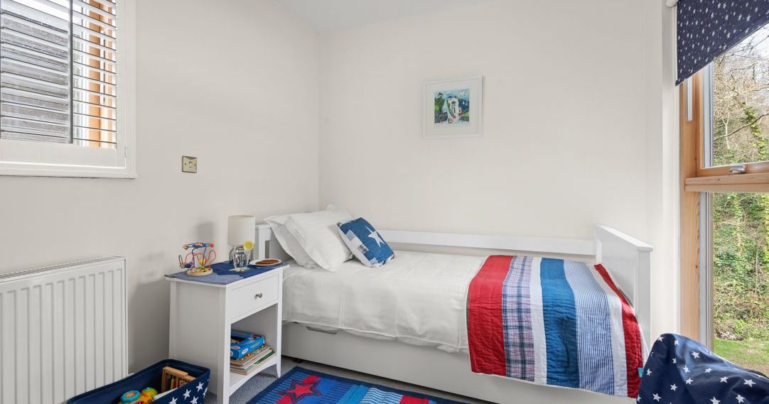 Children's bedroom with a white bed and colorful bedding