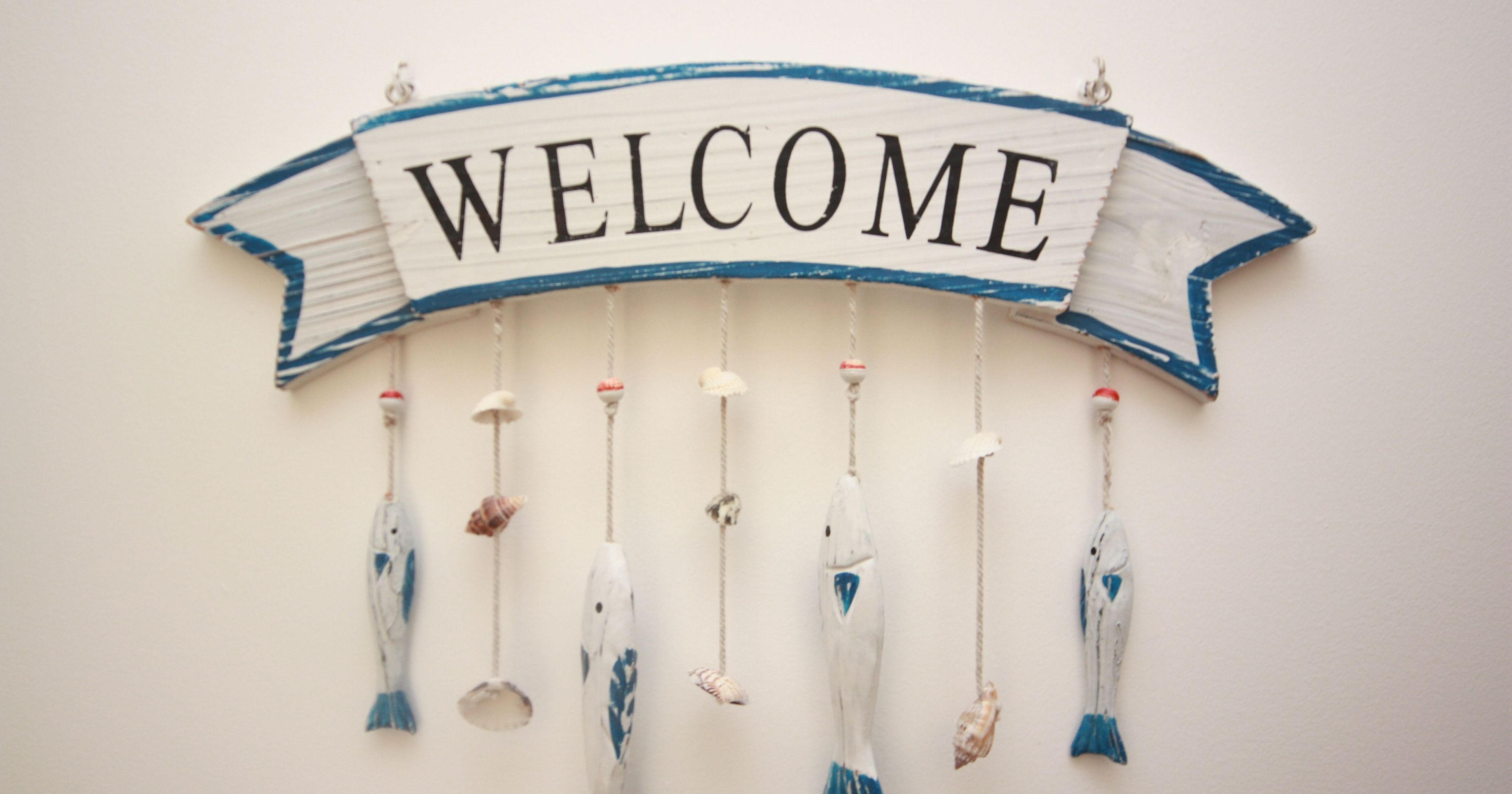 Welcome sign with hanging fish and seashells