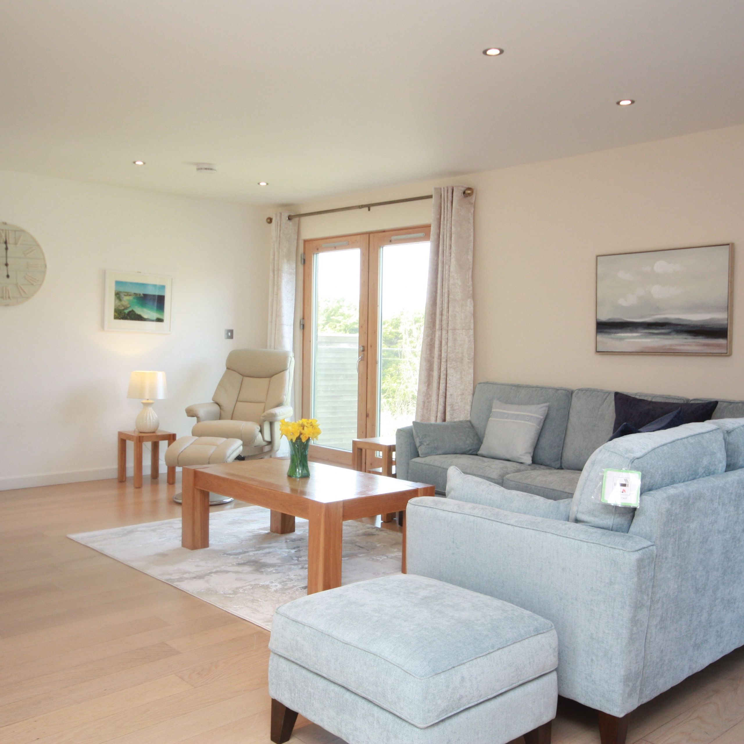 Modern living room with light blue sectional sofa and wooden furniture
