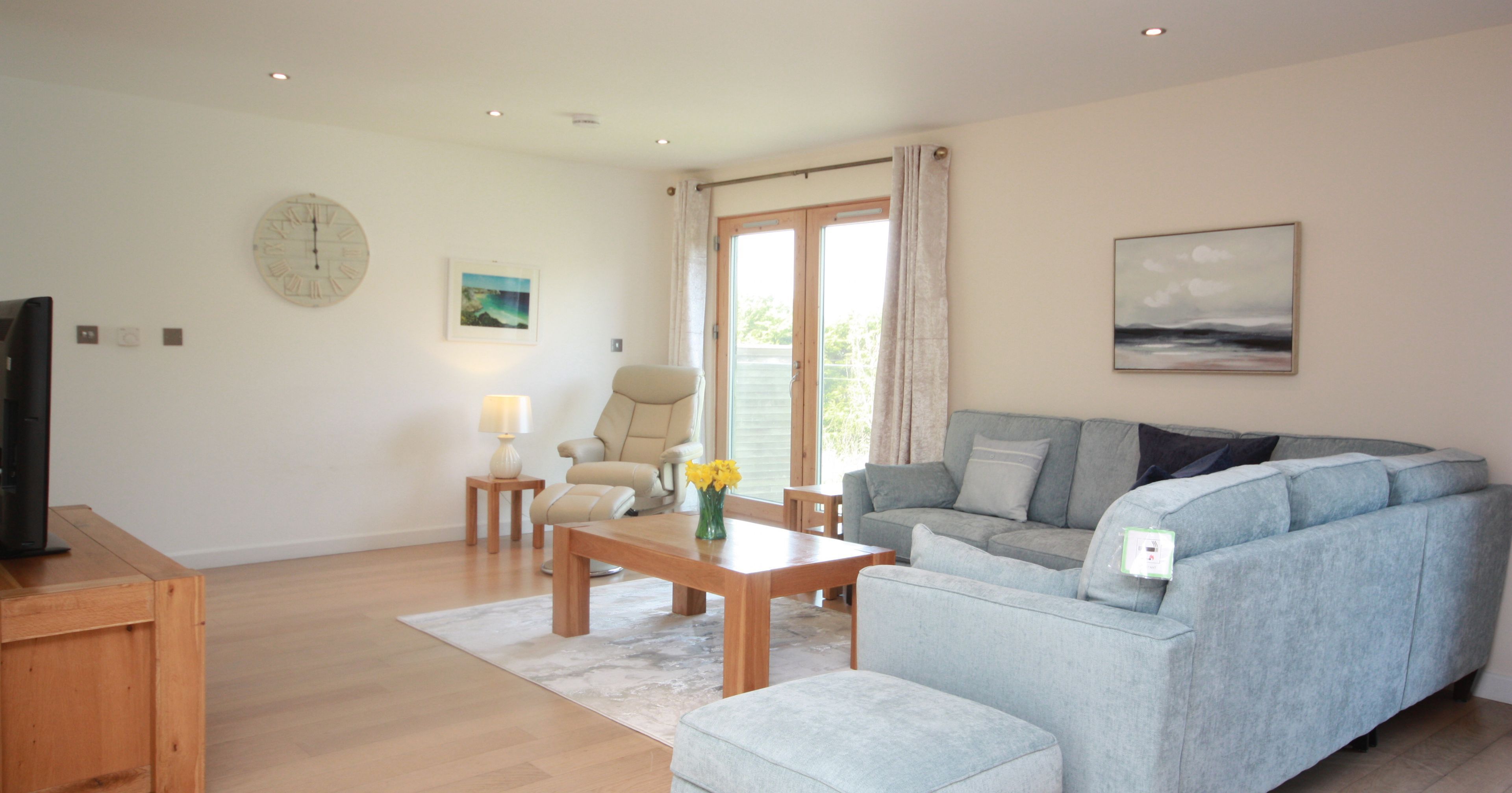 Modern living room with light blue sectional sofa and wooden furniture