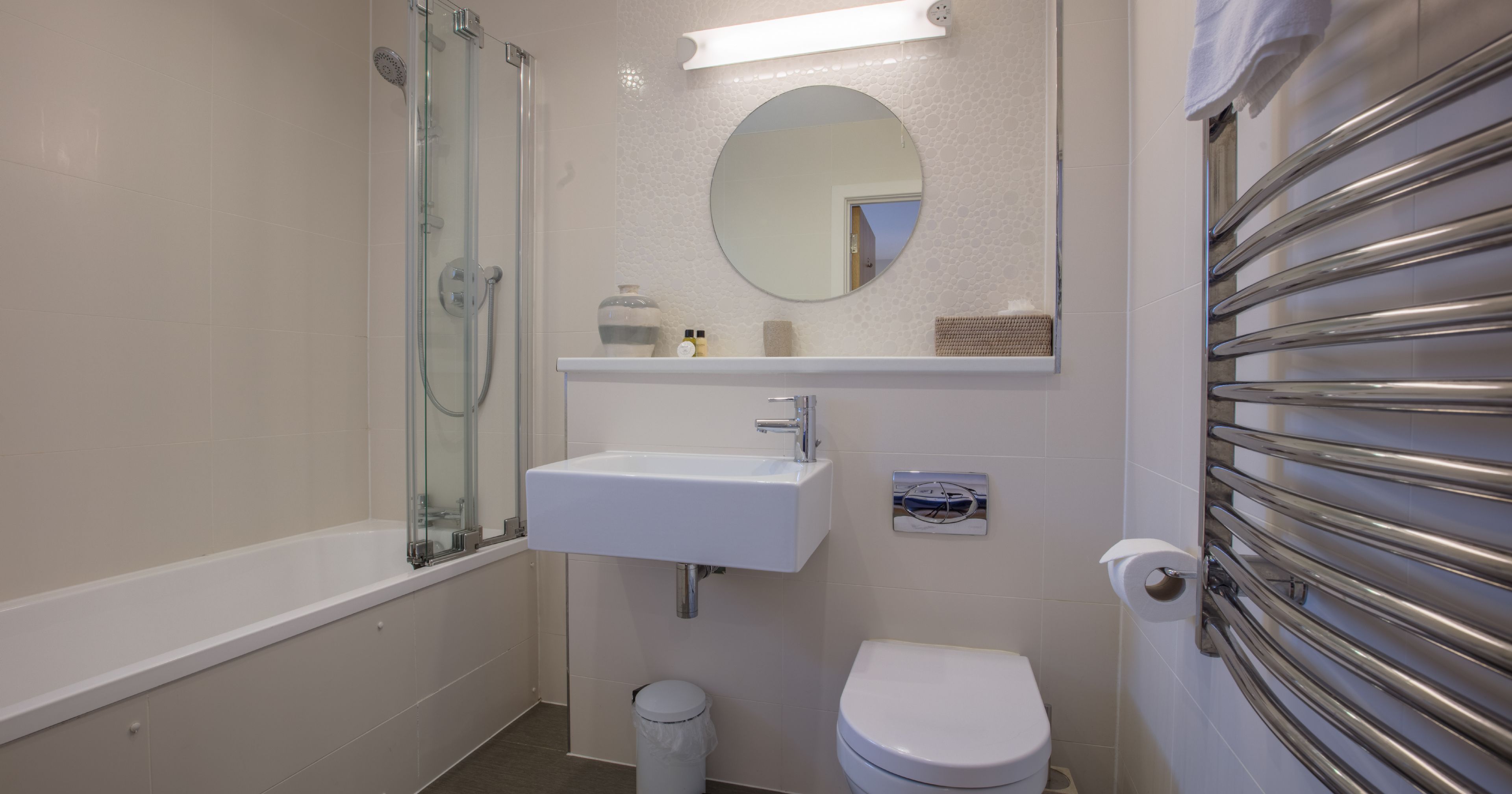 Modern bathroom with bathtub, shower, sink, toilet, and towel warmer