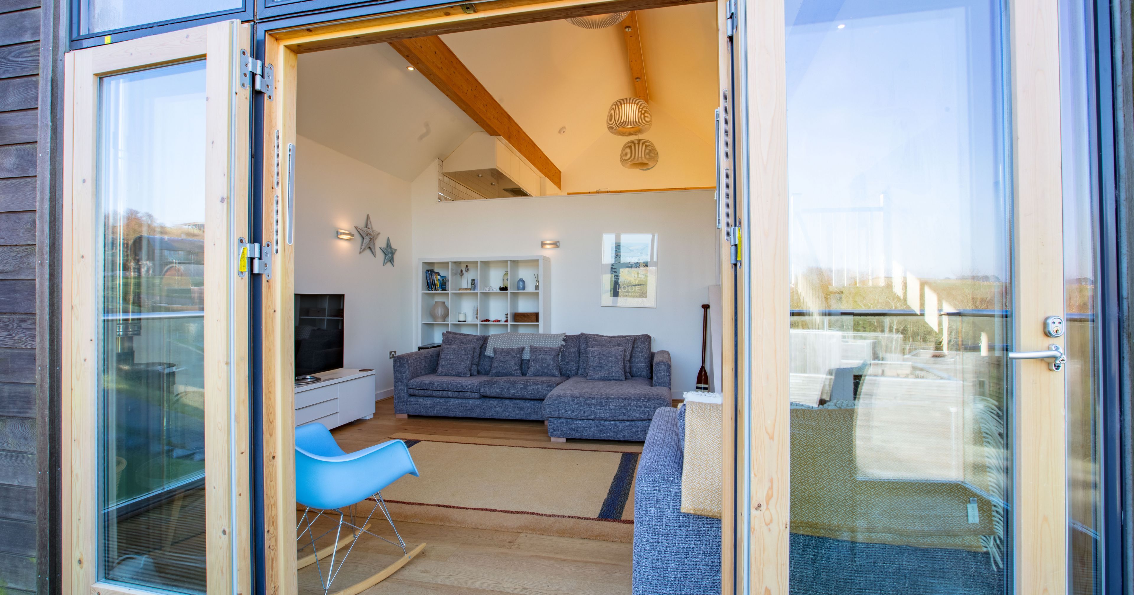 Modern living room with large glass doors open to the outside
